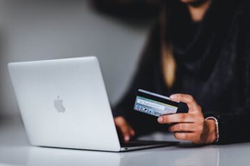 man using ecommerce website and holding credit card